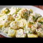 Bowl of creamy Dill Potato Salad with fresh herbs and potatoes