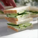 Plateful of easy cucumber sandwiches with fresh ingredients and garnishes