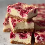 Healthy high protein raspberry cheesecake bars on a plate with fresh raspberries
