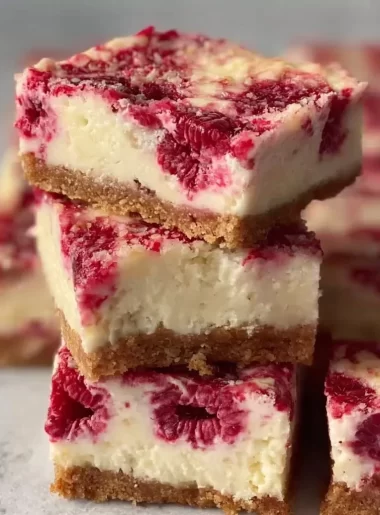 Healthy high protein raspberry cheesecake bars on a plate with fresh raspberries