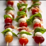 Mini Caprese Skewers with fresh mozzarella, tomatoes, and basil on a platter