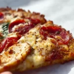 Sliced Chicken Crust Pizza topped with fresh ingredients and cheese