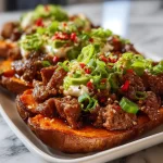 Hot Honey Beef served on sweet potato boats topped with herbs.