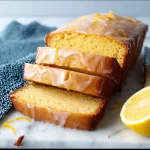 Delicious Lemon Yogurt Cake with a slice of lemon garnish on a white plate