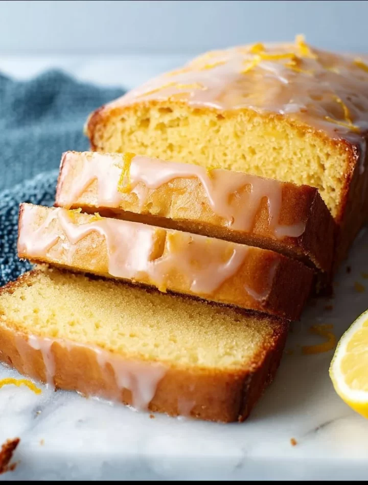 Delicious Lemon Yogurt Cake with a slice of lemon garnish on a white plate