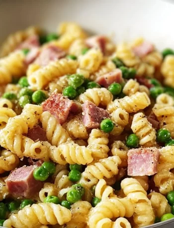 Plate of pasta with peas and ham garnished with parsley