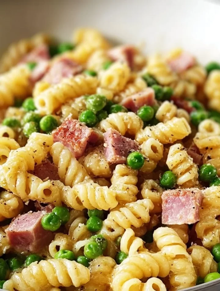 Plate of pasta with peas and ham garnished with parsley