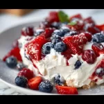 Red White and Blue Cheesecake Salad with strawberries, blueberries, and cream cheese mixture.