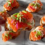 Delicious smoked salmon crostini garnished with herbs and served on a platter