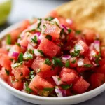 Bowl of refreshing watermelon salsa with diced fruits and herbs