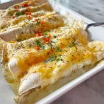 Delicious white chicken enchiladas topped with creamy sauce and cheese