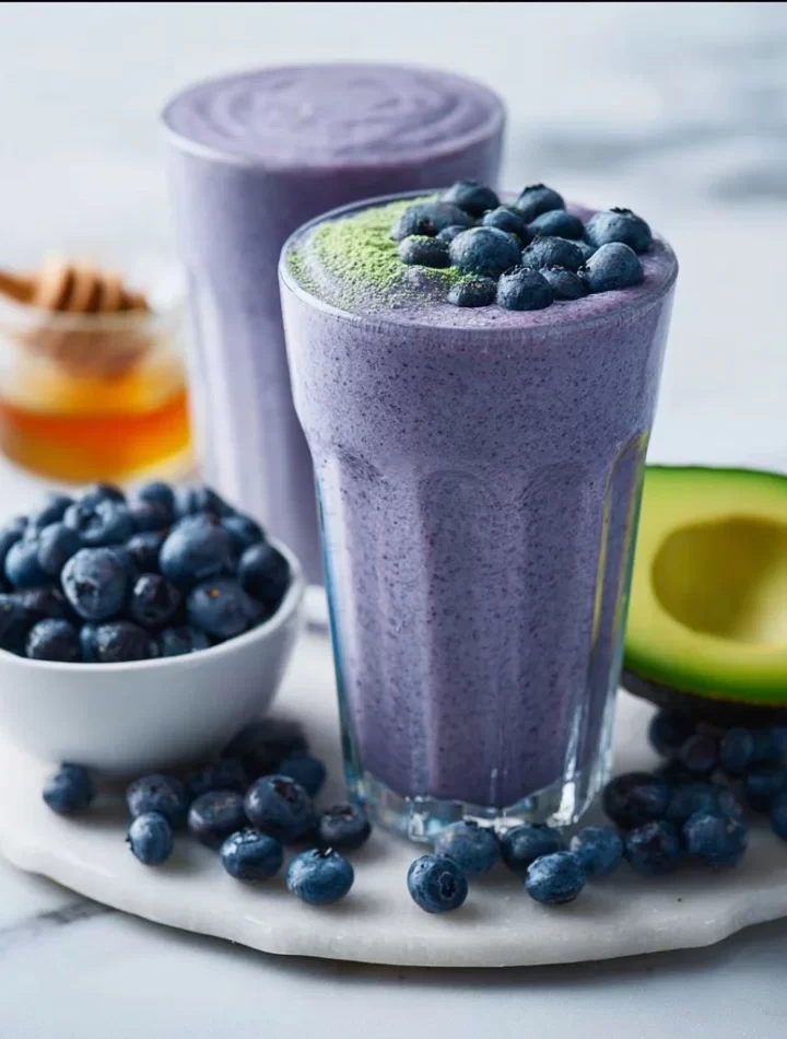 Creamy avocado blueberry smoothie in a glass with fresh fruits