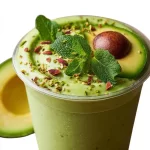Fresh avocado smoothie with mint in a glass, vibrant green color.