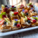 Variety of beach snacks including fruits, chips, and sandwiches for a sunny day.