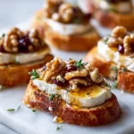 Elegant Brie crostini with honey and walnuts on a serving platter