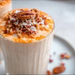 Carrot Cake Smoothie in a glass topped with cream and spices