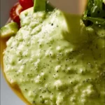 Creamy avocado lime dressing drizzled over a fresh salad bowl