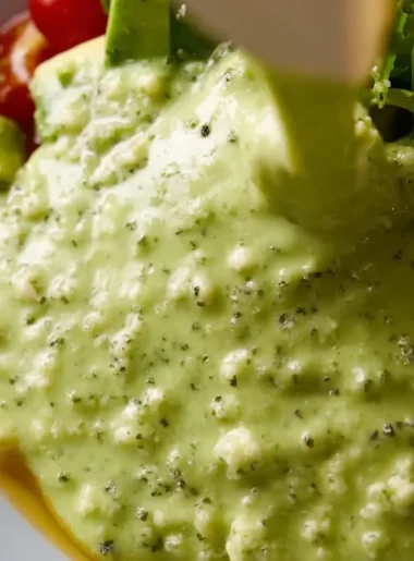 Creamy avocado lime dressing drizzled over a fresh salad bowl