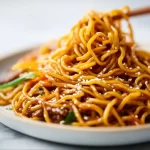Delicious plate of easy hibachi noodles garnished with vegetables and sauce