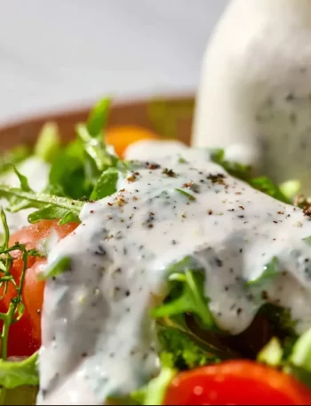 Homemade ranch dressing in a serving bowl with fresh vegetables