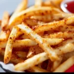 Crispy French fries cooking on a Blackstone griddle.
