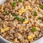 Healthy Blackstone Hibachi Rice served in a bowl with vegetables and garnishes.