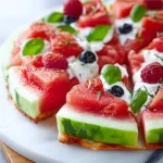 Colorful healthy watermelon fruit pizza topped with yogurt and berries