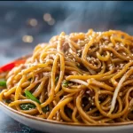 Delicious homemade Hibachi Noodles served in a bowl with vegetables and sauce.