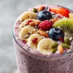 High-protein berry smoothie in a glass with fresh berries and ingredients