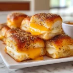 Mini Grilled Cheese Hawaiian Rolls served on a plate with cheese oozing out