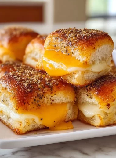 Mini Grilled Cheese Hawaiian Rolls served on a plate with cheese oozing out