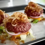 Oklahoma onion burgers topped with caramelized onions and served on fresh buns.
