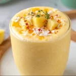 Delicious Pineapple Orange Smoothie in a glass with fresh fruits