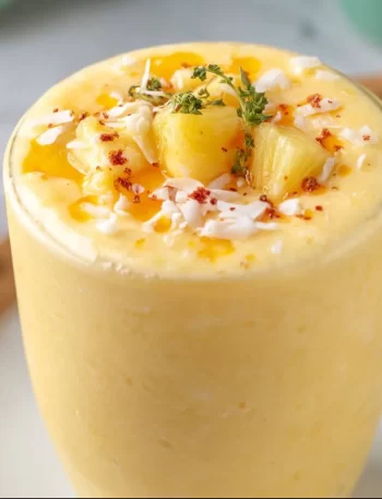 Delicious Pineapple Orange Smoothie in a glass with fresh fruits