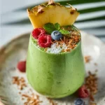 A refreshing detox green smoothie with spinach, kale, and mixed fruits in a glass.