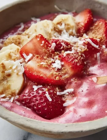 Strawberry banana smoothie bowl topped with fresh fruits and granola