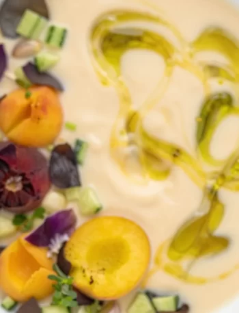 Chilled peach soup served in a bowl, garnished with mint leaves