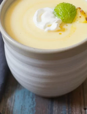 Bowl of chilled pineapple soup with garnishes as a refreshing summer dish