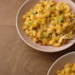 Creamy Veggie Mac and Cheese served in a bowl, topped with fresh herbs.