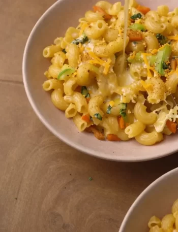 Creamy Veggie Mac and Cheese served in a bowl, topped with fresh herbs.