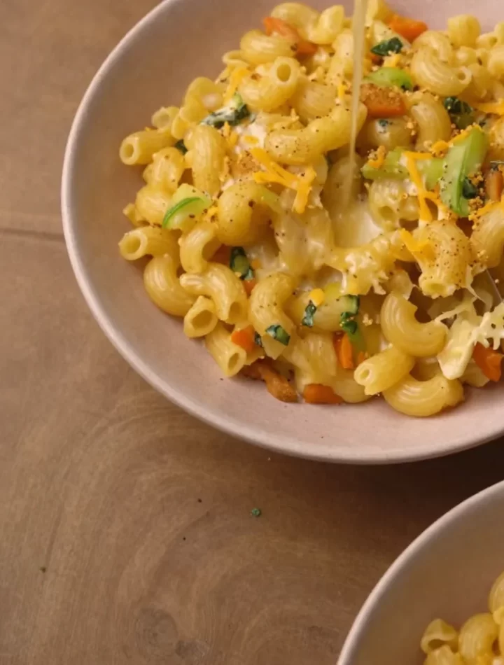 Creamy Veggie Mac and Cheese served in a bowl, topped with fresh herbs.