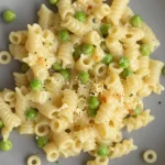 Creamy parmesan pea pasta dish served with fresh peas and cheese