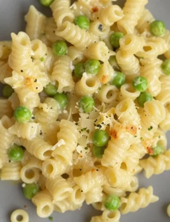 Creamy parmesan pea pasta dish served with fresh peas and cheese