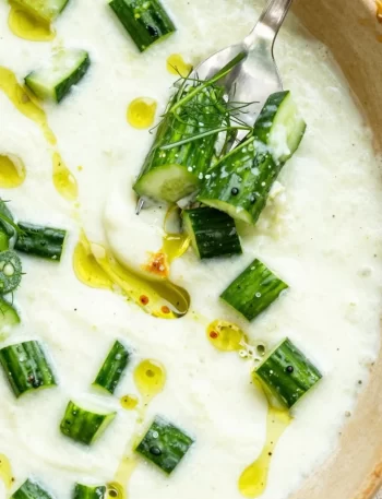 Fresh cucumber gazpacho served in a bowl with herbs and garnishes