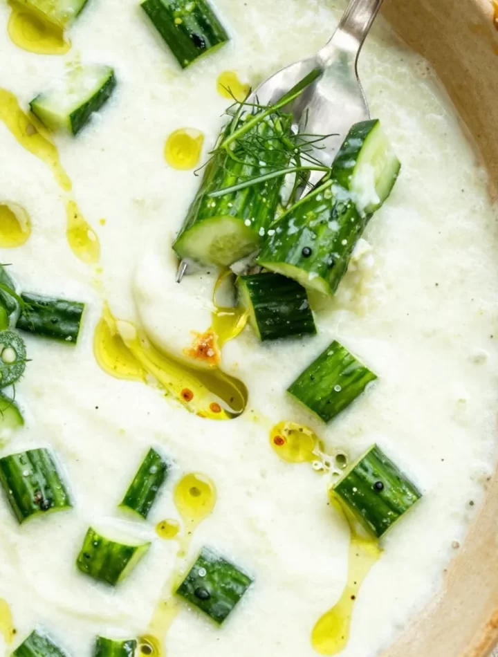 Fresh cucumber gazpacho served in a bowl with herbs and garnishes