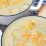 Bowl of minute creamy zucchini soup garnished with fresh herbs