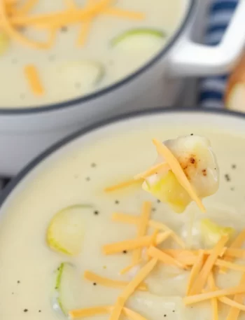 Bowl of minute creamy zucchini soup garnished with fresh herbs