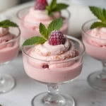 Delicious no-bake raspberry mousse dessert topped with fresh raspberries.