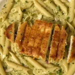 One-pot creamy pesto pasta dish garnished with fresh basil