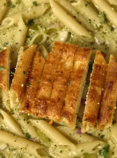 One-pot creamy pesto pasta dish garnished with fresh basil